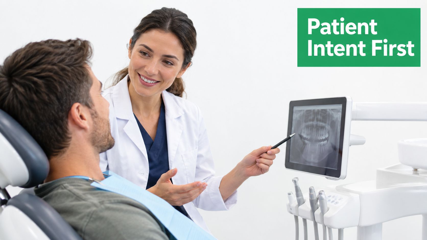 A smiling female dentist pointing at a digital dental X-ray on a monitor for her male patient.
